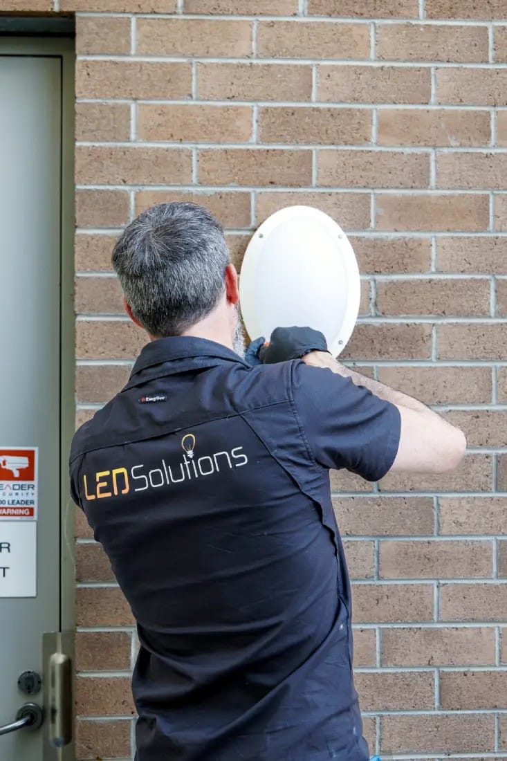 Kieran fitting an outdoor wall light on a brick wall