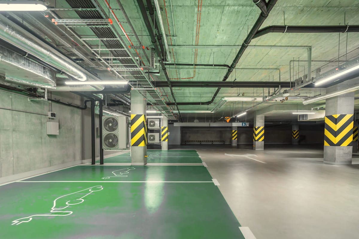 An underground car park with marked electric vehicle charging bays