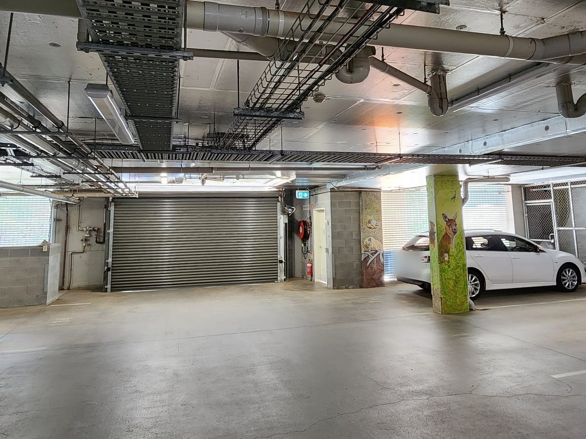 Car park lighting left on under the cable trays of an empty strata car park
