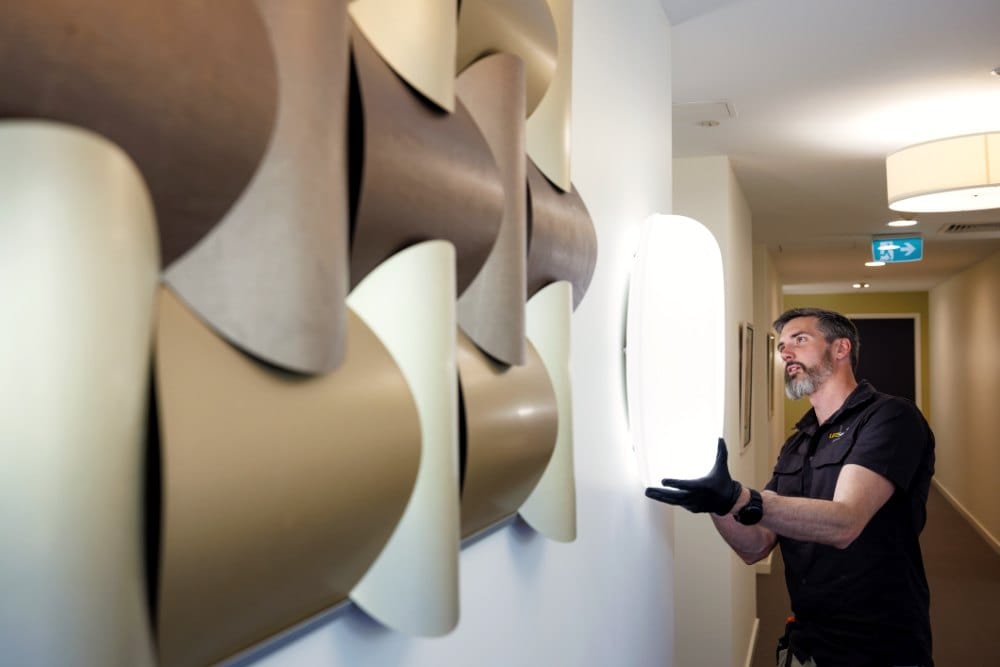 Feature wall lights along a building corridor, with Kieran fitting one at the far end
